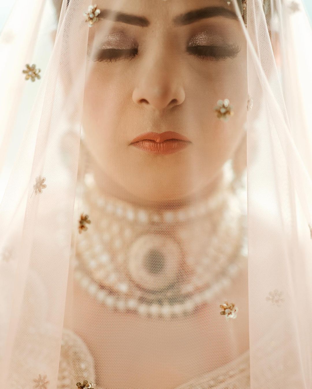Bride's face through a sheer veil