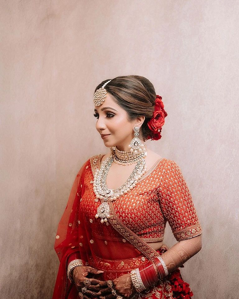 Bride portrait in orange and red against plain backdrop