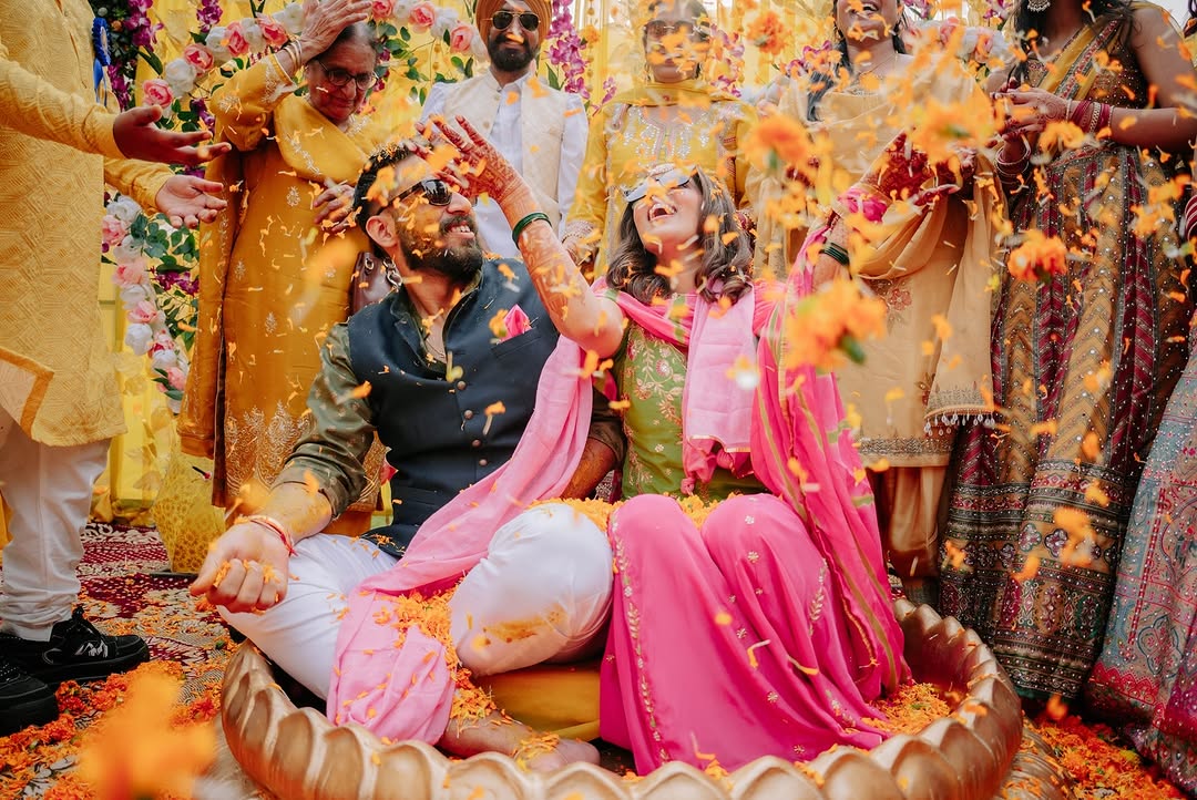 Couple sitting together during haldi in pink and green