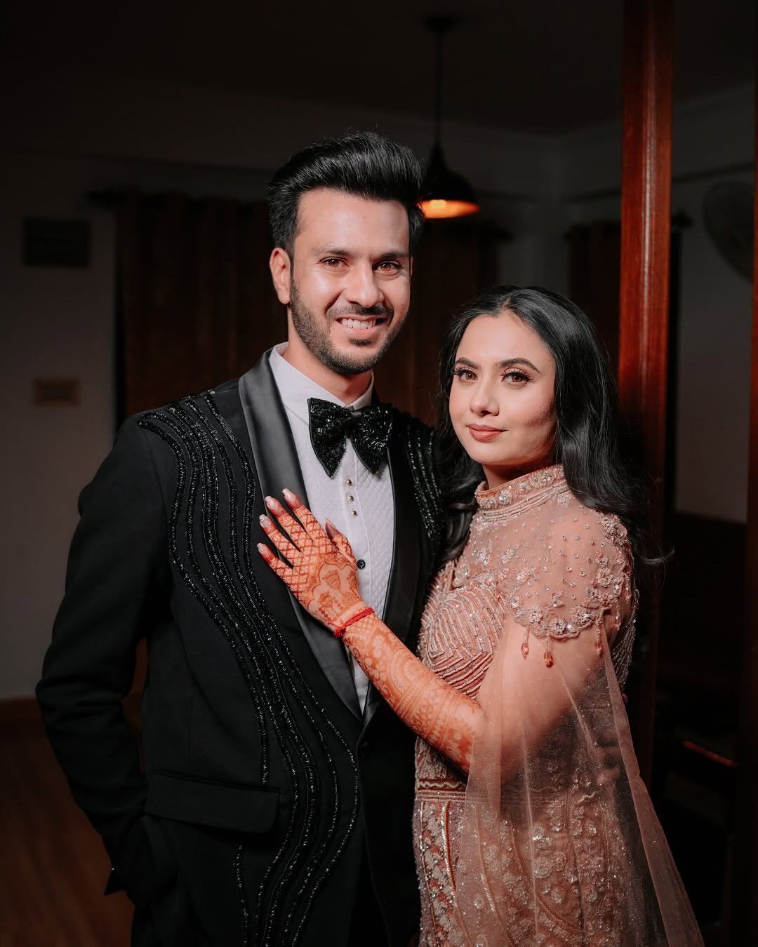 Couple at the reception in black tuxedo and pink gown